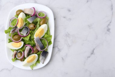 Ringa balıklı nefis salata, yumurta ve sebzeler beyaz mermer masada, üst manzara. Metin için boşluk