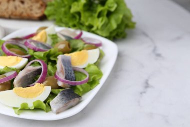 Ringa balıklı lezzetli salata, yumurta ve sebzeler beyaz mermer masada, yakın plan. Metin için boşluk
