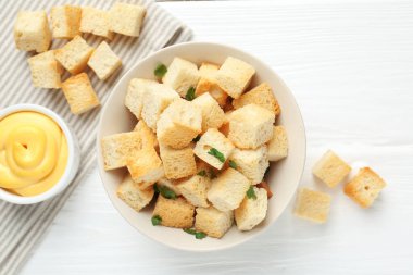 Beyaz ahşap masada maydanozlu ve soslu çıtır çıtır kızarmış ekmek.