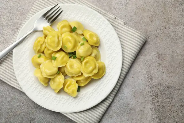 Yeşil soğanlı ve çatallı lezzetli hamur tatlısı gri desenli masa, üst manzara. Metin için boşluk