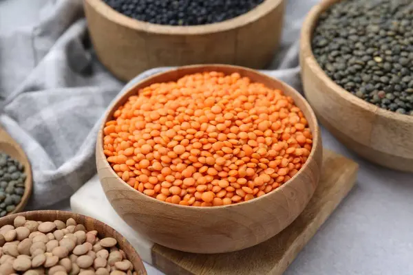 Aydınlık masada farklı türde mercimek, yakın plan.