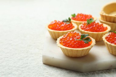 Kırmızı havyarlı tartlar ve bej masadaki maydanozlar, yakın plan. Metin için boşluk