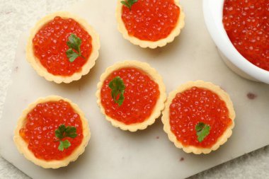 Kırmızı havyarlı turta ve bej arka planda maydanoz.