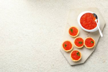 Kırmızı havyarlı tart ve bej arka planda maydanoz, üst manzara. Metin için boşluk