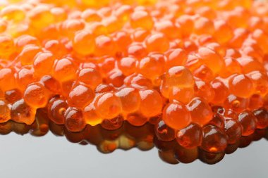 Gri ayna yüzeyinde kırmızı havyar, yakın plan.