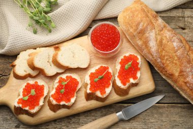 Kırmızı havyarlı sandviçler ve ahşap masada mikroyeşiller.