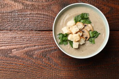 Ekmek arası mantar kremalı çorba ve ahşap masa üzerinde maydanoz. Metin için boşluk