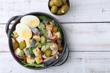 Ringa balıklı, yumurtalı, sebzeli ve beyaz ahşap masada zeytinli nefis salata. Metin için boşluk