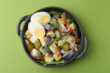 Ringa balıklı lezzetli salata, yeşil arka planda yumurta ve sebzeler, üst manzara.