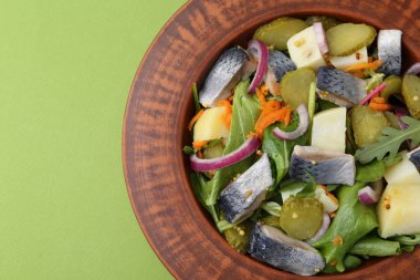 Ringa balıklı lezzetli salata, sebze ve hardal yeşil arka planda, üst manzara. Metin için boşluk