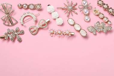 Different hair clips on pink background, flat lay. Space for text