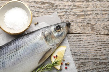 Salamura ringa balığı ve baharatlar ahşap masada, düz yerde. Metin için boşluk
