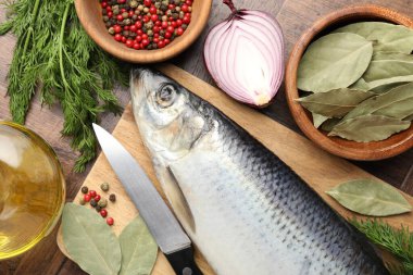 Tuzlu ringa balığı, baharat ve bıçak ahşap masada, düz yerde.