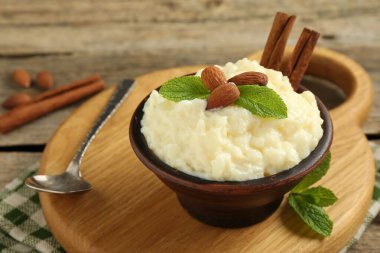 Tahta masada servis edilen bademli, nane ve tarçınlı lezzetli sütlaç, yakın plan.
