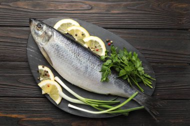 Ahşap masada tuzlanmış ringa balığı ve baharat, üst manzara.