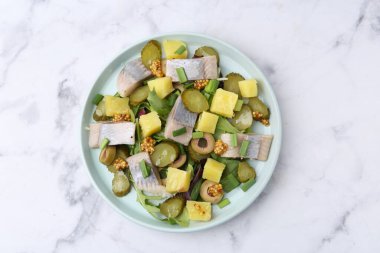 Beyaz mermer masada ringa balıklı nefis bir salata.