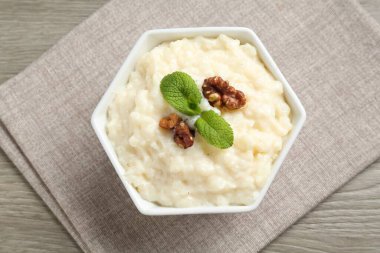 Cevizli lezzetli sütlaç ve ahşap masada nane şekeri.