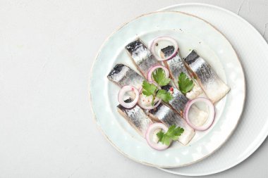 Beyaz masadaki baharatlı ve soğanlı lezzetli ringa balıkları. Metin için boşluk