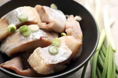 Masada yeşil soğanlı lezzetli ringa balıkları, yakın plan.