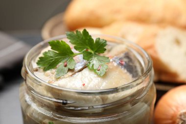 Kavanozda maydanoz ve baharatlı lezzetli ringa balıkları, yakın plan.