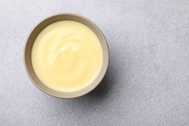 Açık gri masada kasede vanilyalı puding, üst manzara. Metin için boşluk