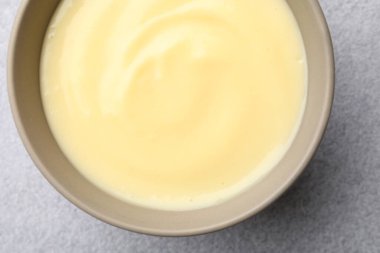 Açık gri masada kasede vanilyalı puding, üst manzara.