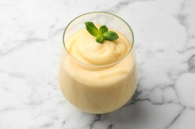 Beyaz mermer masada naneli vanilyalı puding, yakın plan.