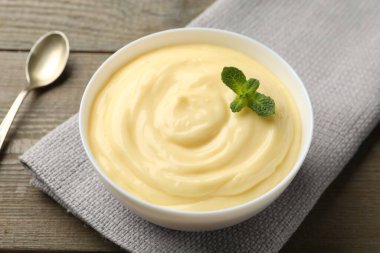 Tahta masada servis edilen naneli vanilyalı puding, yakın plan.