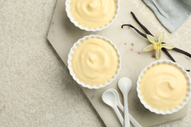 Kaşıklar, kapsüller ve çiçekli leziz vanilyalı puding.