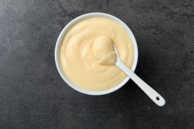 Siyah masadaki kaşıklı vanilyalı puding.