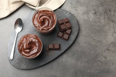 Lezzetli puding ve gri masada bir parça çikolata. Metin için boşluk