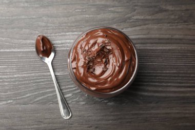 Bardakta çikolatalı puding ve ahşap masada kaşık.