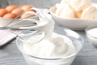 Krem şantili çırpı çırpma ve gri masadaki diğer malzemeler, yakın plan. Kurabiye pişiriyorum.