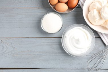 Lezzetli ev yapımı kurabiyeler, malzemeler ve gri ahşap masa üzerinde çırpma çırpma, düz yatak. Metin için boşluk