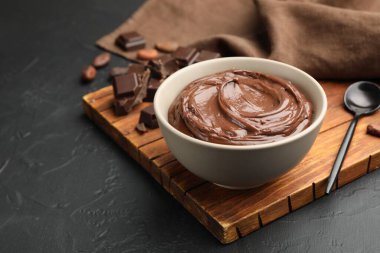 Kasede lezzetli puding, siyah masada çikolata ve kakao çekirdeği parçaları, yakın plan. Metin için boşluk