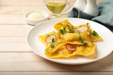 Mikroyeşillikli lezzetli ravioli ve ahşap masada turp, yakın plan.