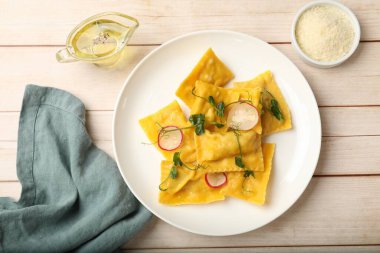 Ahşap masada mikroyeşillikli, turplu, yağlı ve parmesanlı lezzetli ravioli.