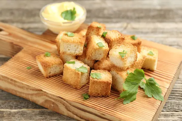 Tahta masada maydanoz ve sos dilimlenmiş çıtır çıtır ekmek, yakın plan.