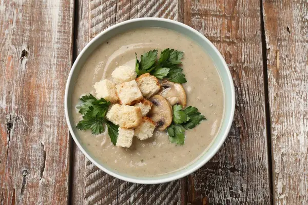 Ekmek arası mantar kremalı çorba ve ahşap masada maydanoz.