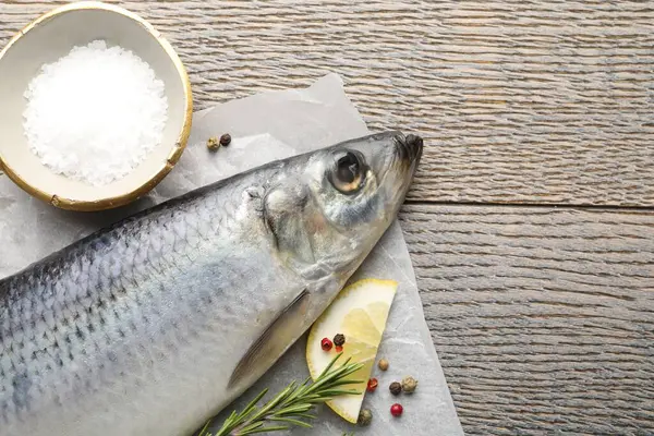 Salamura ringa balığı ve baharatlar ahşap masada, düz yerde. Metin için boşluk