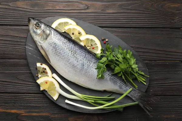 Ahşap masada tuzlanmış ringa balığı ve baharat, üst manzara.