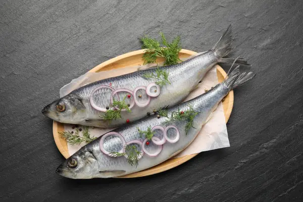 Lezzetli ringa balıkları, siyah masa üzerinde baharatlar, üst manzara.