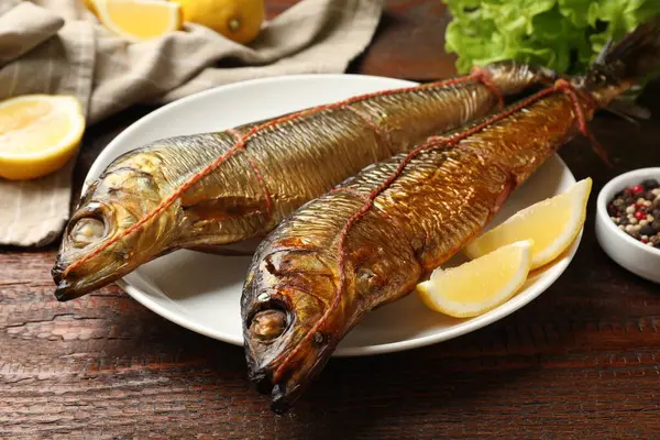 Lezzetli tütsülenmiş ringa balığı, ahşap masada dilimler, yakın plan.