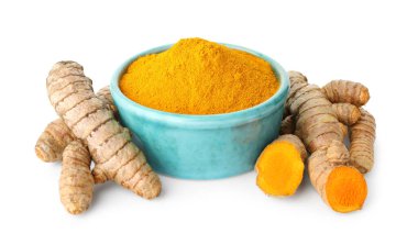 Kabın içindeki zerdeçal tozu ve beyaza izole edilmiş kökler