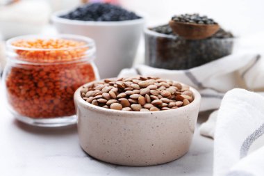 Beyaz masada farklı türde mercimek, yakın plan.
