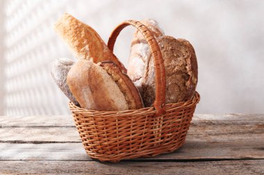 Tahta masadaki sepetin içinde farklı somunlar, yakın çekim.