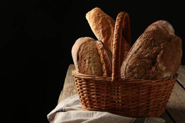 Tahta masadaki sepetin içinde farklı somunlar, yakın plan. Metin için boşluk