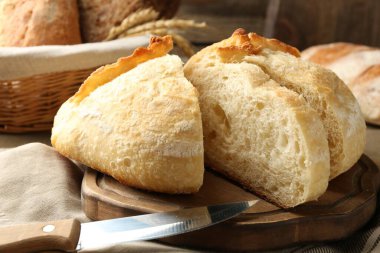 Taze pişmiş ekmek ve bıçağı masaya koyun, yakın plan.