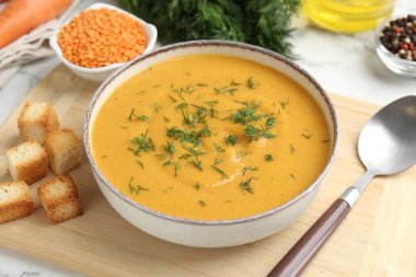 Lezzetli mercimek kremalı çorba, dereotu ve malzemeler beyaz masada, yakın plan.