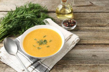 Ahşap masada servis edilen dereotlu mercimek kremalı leziz çorba.